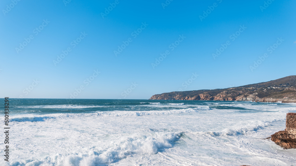 Amazing Atlantic Ocean with waves and rocks in Portugal. Summer holidays and rest. Blue sea background