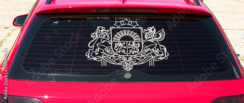State coat of arms of the Republic of Latviaon a car window.