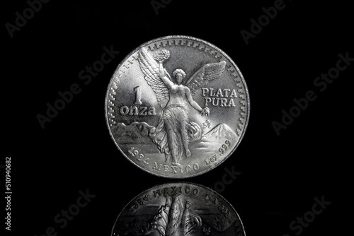one ounce Mexican Libertad Silver Bullion Coin against a black background with reflection photo