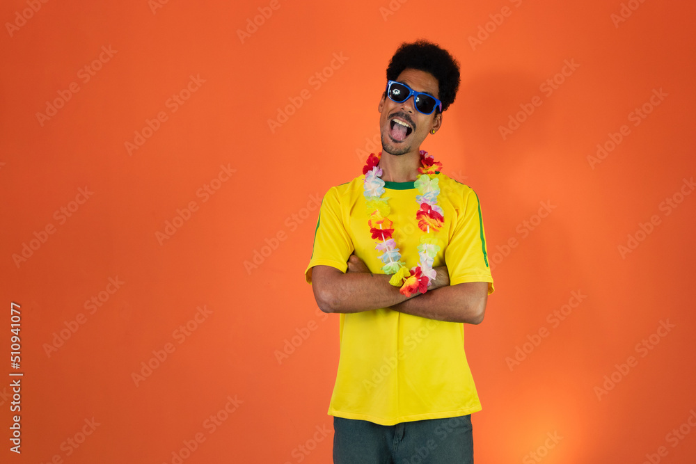 Man in yellow soccer outfit celebrating Isolated on Orange Background. Excited football fan cheering. Man in yellow soccer outfit celebrating Isolated on Orange Background. Excited football fan cheering.