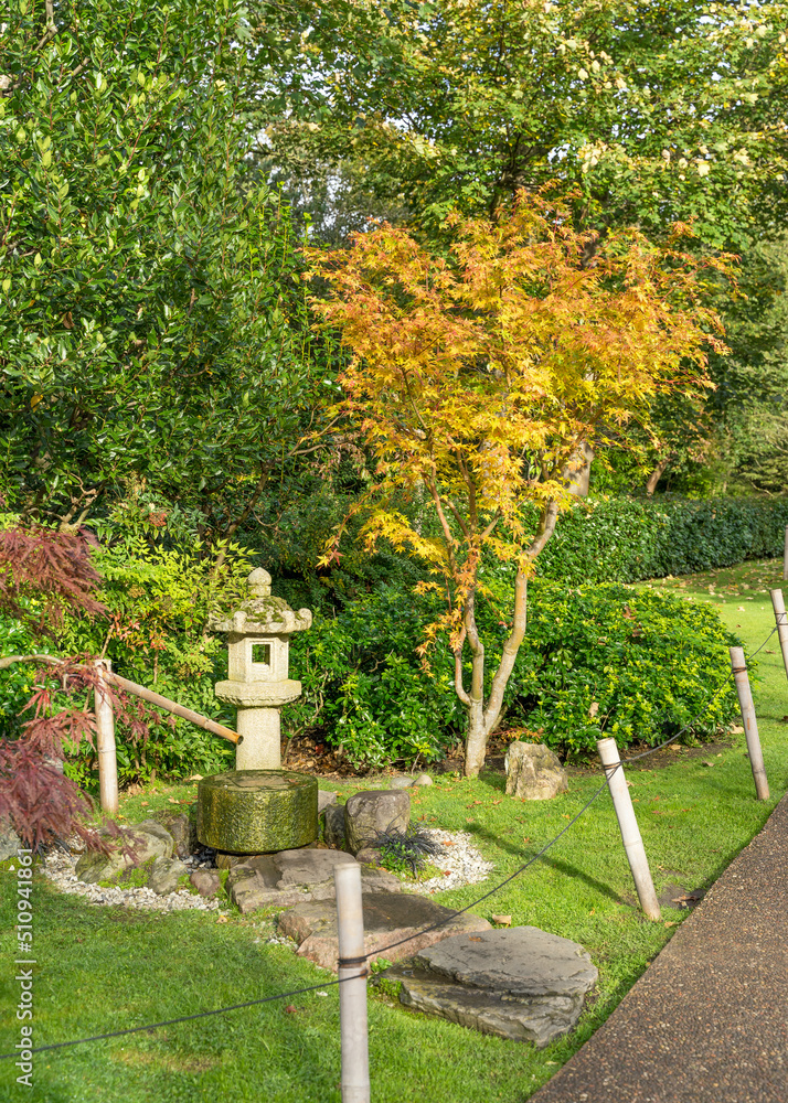 Japanese themed garden with a lucky coin fountain and oriental stone lantern. Surrounded by the autumn colours of the trees. Japanese themed garden with a lucky coin fountain and oriental stone lantern. Surrounded by the autumn colours of the trees.