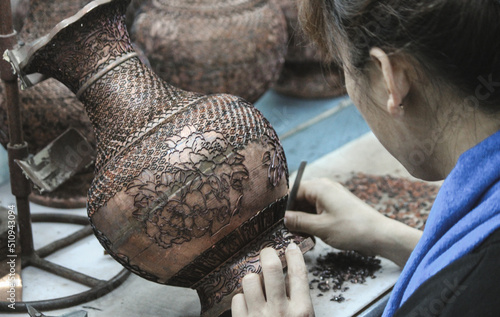 photo of a craftsman making Cloisonné (an ancient technique for decorating metalwork objects with colored material) in china