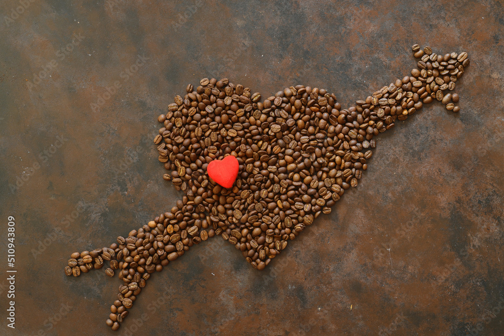 Obraz premium Roasted coffee beans in heart shaped bowl on dark background. Love coffee concept. Top view flat lay with copy space