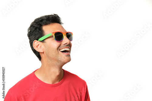 Brunette boy smiling with lgbtq rainbow glasses in red t-shirt © Alvaro