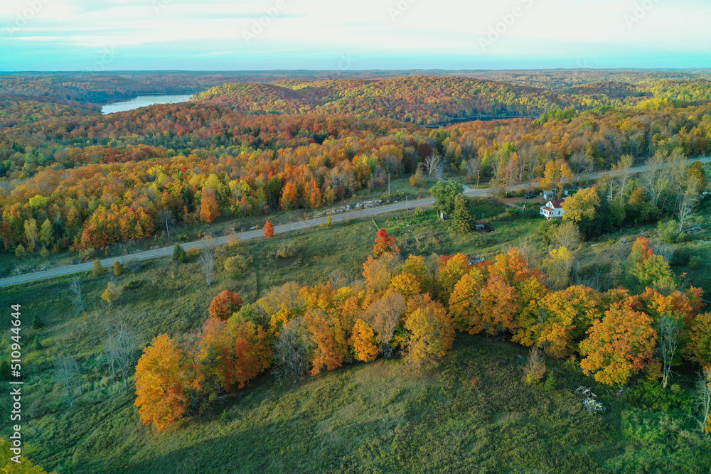 Aerial shots of fields Forest Lakes roads and a farmhouse during an Autumn sunset