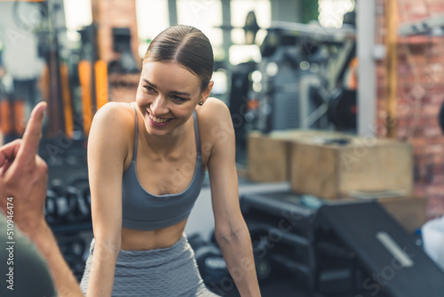Exercise endorphins concept. Young attractive fit slim woman talks with someone at the gym and smiles broadly. High quality photo