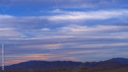 Tranquil Mojave Desert landscape scene with beautiful clouds shown at dusk.
