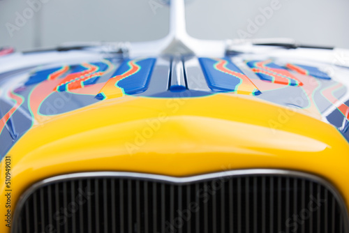 The hood of a hot rod car with painted flames