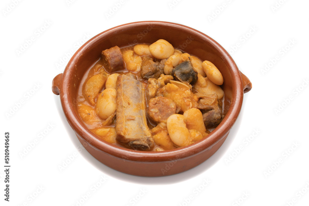 A terracotta plate with Asturian fabada, a typical Spanish bean stew, on a white background. Spanish food concept. A terracotta plate with Asturian fabada, a typical Spanish bean stew, on a white background. Spanish food concept.