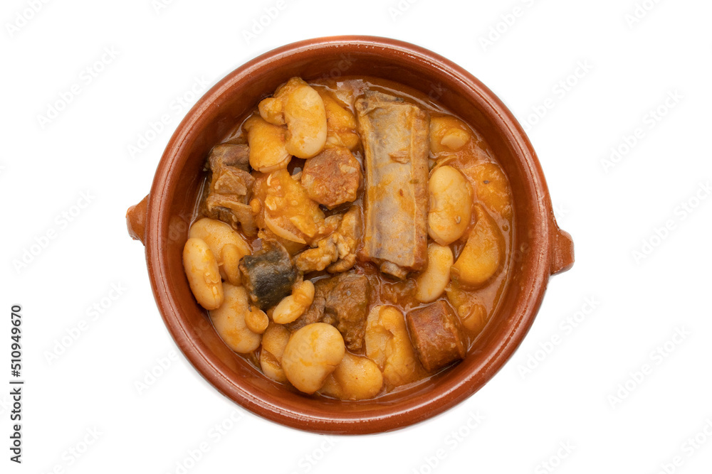A terracotta plate with Asturian fabada, a typical Spanish bean stew, on a white background. Spanish food concept. A terracotta plate with Asturian fabada, a typical Spanish bean stew, on a white background. Spanish food concept.