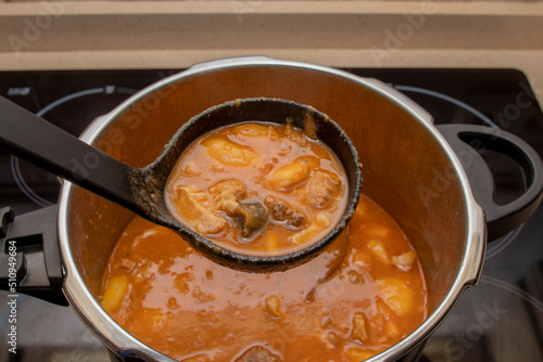 An open pressure cooker with a bean stew, viewed from above. Spanish food concept. Typical Asturian Fabada stew. © mialcas