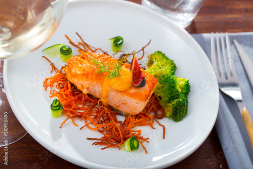 Image of deliciously steak of fried salmon with smoked carrots, broccoli and fig served on plate