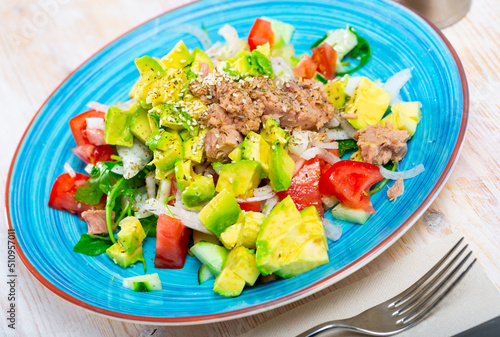 Plate of tasty salad with tuna, corn, tomatoes and arugula
