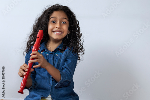 Foto Latin American girl smiling and happy holding her soprano recorder