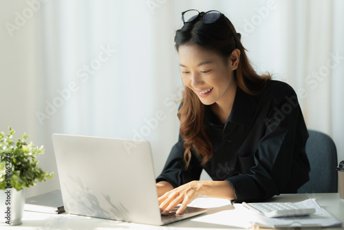 Charming Asian Business Woman working at office. Account and finance concept.