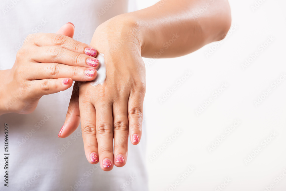 Closeup young Asian woman applying lotion cosmetic moisturizer cream on her behind the palm skin hand, studio shot isolated on white background, Healthcare medical and hygiene skin body care concept Closeup young Asian woman applying lotion cosmetic moisturizer cream on her behind the palm skin hand, studio shot isolated on white background, Healthcare medical and hygiene skin body care concept