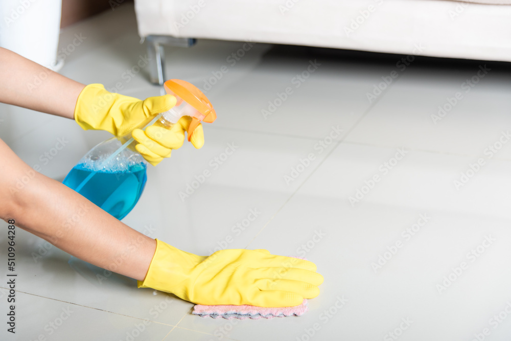 Asian woman wearing yellow rubber glover with cloth rag and detergent spray cleaning floor at home in living room, Female hands wash cleaner, housework and housekeeping concept Asian woman wearing yellow rubber glover with cloth rag and detergent spray cleaning floor at home in living room, Female hands wash cleaner, housework and housekeeping concept