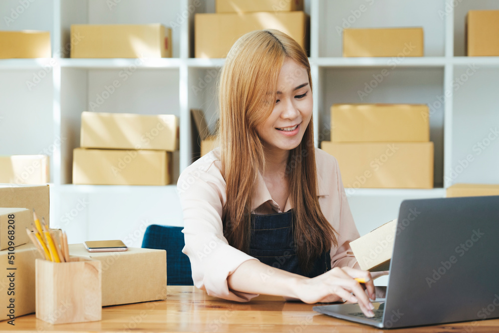 Online small business owner writing address on parcel box. Online small business owner writing address on parcel box.