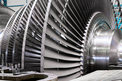 Rotor with blades of powerful steam turbine in workshop photo