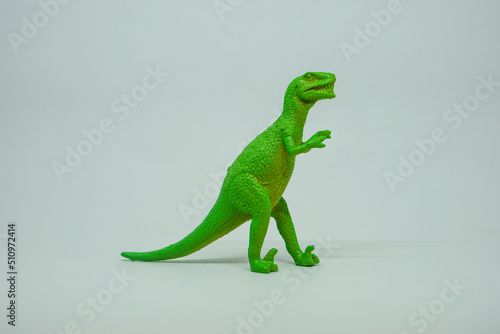 Side view of plastic green Tyrannosaurus rex dinosaur plastic toy for kids  isolated on a studio lighting background