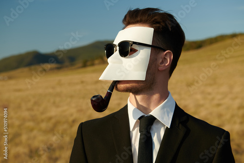 masked person smoking pipe photo