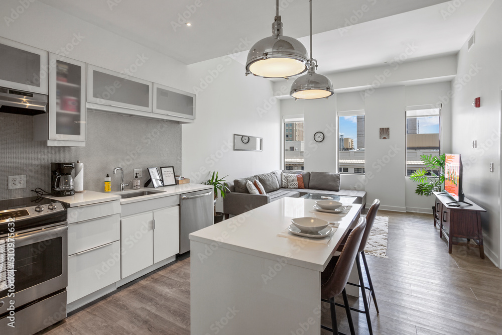 Fototapeta premium beautiful kitchen in new luxury home with island, pendant lights, hardwood floors, and stainless steel appliances