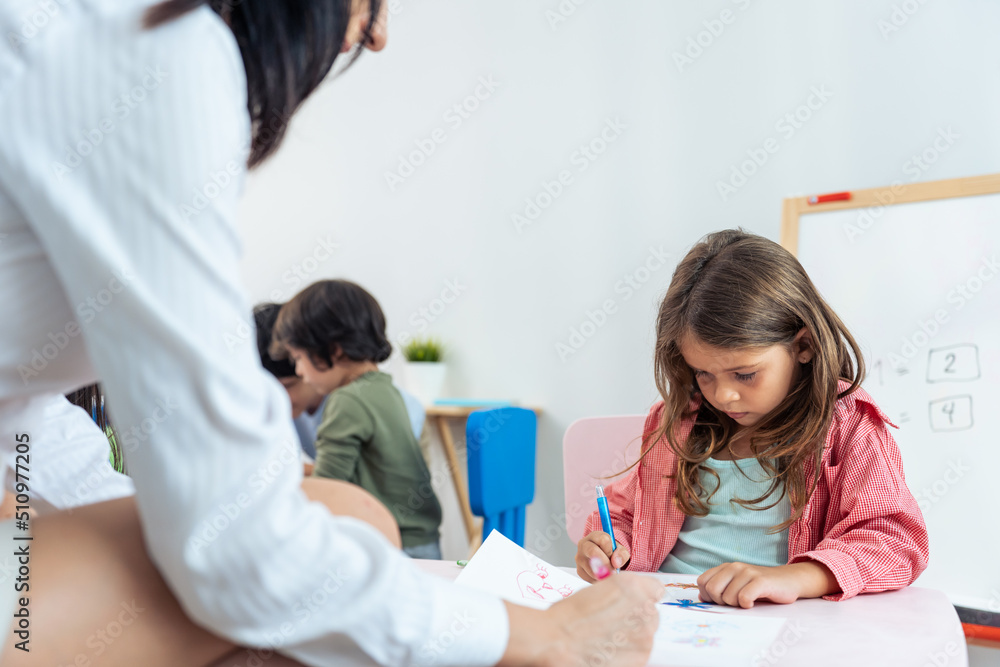 Caucasian beautiful woman teacher teaching a lesson to kid at school. Caucasian beautiful woman teacher teaching a lesson to kid at school.