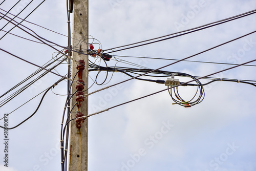 Messy of the local electric cables line with clear skies background.