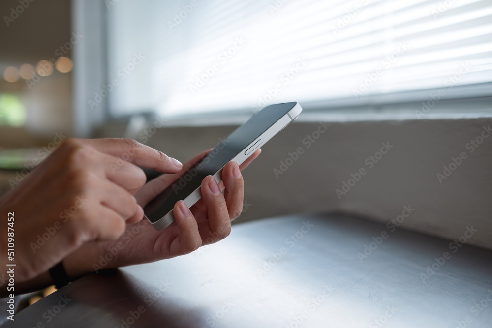 Closeup image of a woman using and touching on mobile phone screen