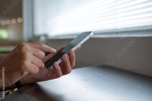 Closeup image of a woman using and touching on mobile phone screen