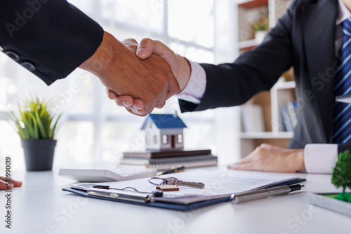 Handshake Real estate brokerage agent Deliver a sample of a model house to the customer, mortgage loan agreement Making lease and buy and sell house And contract home insurance mortgage loan concept photo