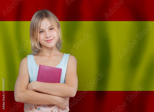 Girl with book on flag of Spain background. School and education in Spain concept.