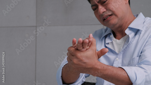 An Asian man has tingling and numbness in his hand which causes beriberi. photo