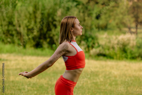 Young attractive blonde healthy woman doing fitness stretching outdoors