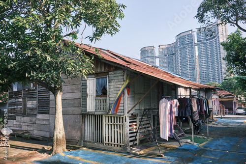 Overall view of old wooden houses with modern buildings in the background at Kampung Baru in Kuala Lumpur Malaysia.