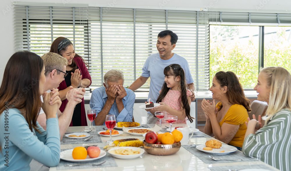 Happy family gathering enjoying having lunch together at home. Child daughter celebration around dining table with parents, grandparents and multi-generation family Happy family gathering enjoying having lunch together at home. Child daughter celebration around dining table with parents, grandparents and multi-generation family