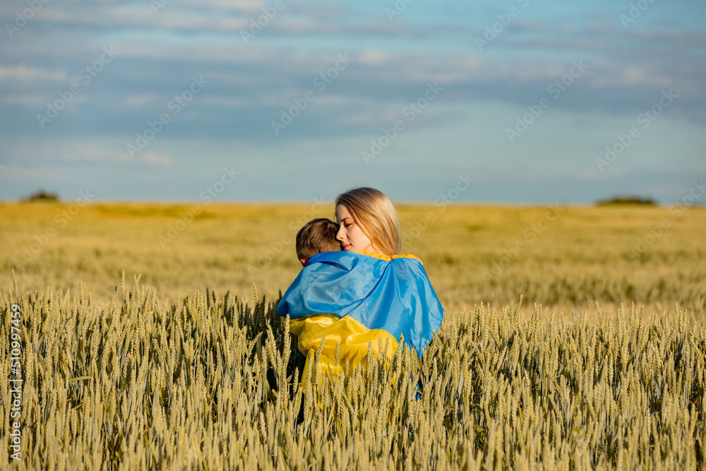 Mother with son in ukrainian flag in wheat field Mother with son in ukrainian flag in wheat field