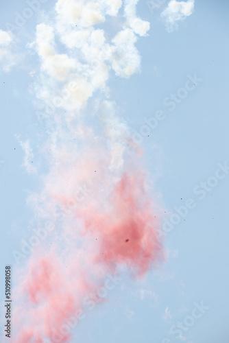 Red white smoke in the air against the sky.