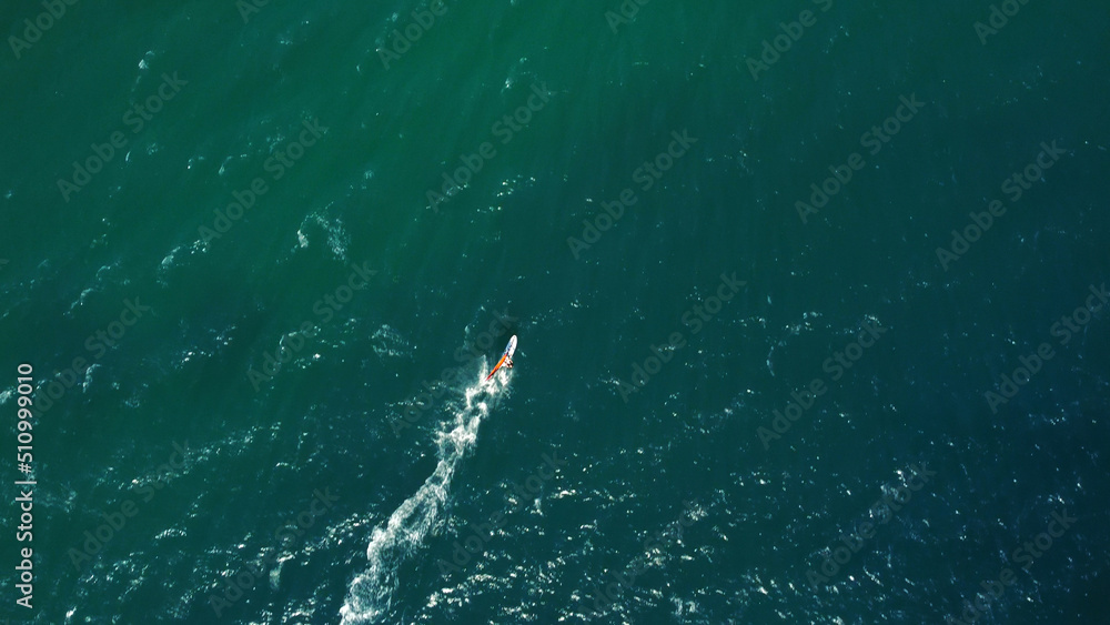 Aerial drone view of windsurfer enjoying on blue sea ocean waves..