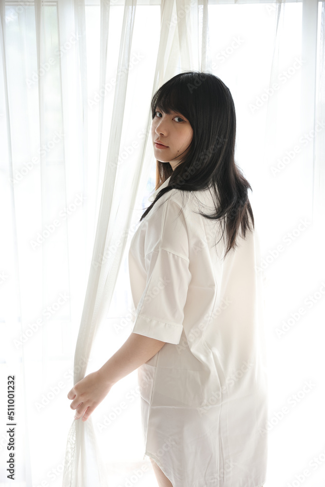 Beautiful young woman waking up in the morning at white bedroom Beautiful young woman waking up in the morning at white bedroom