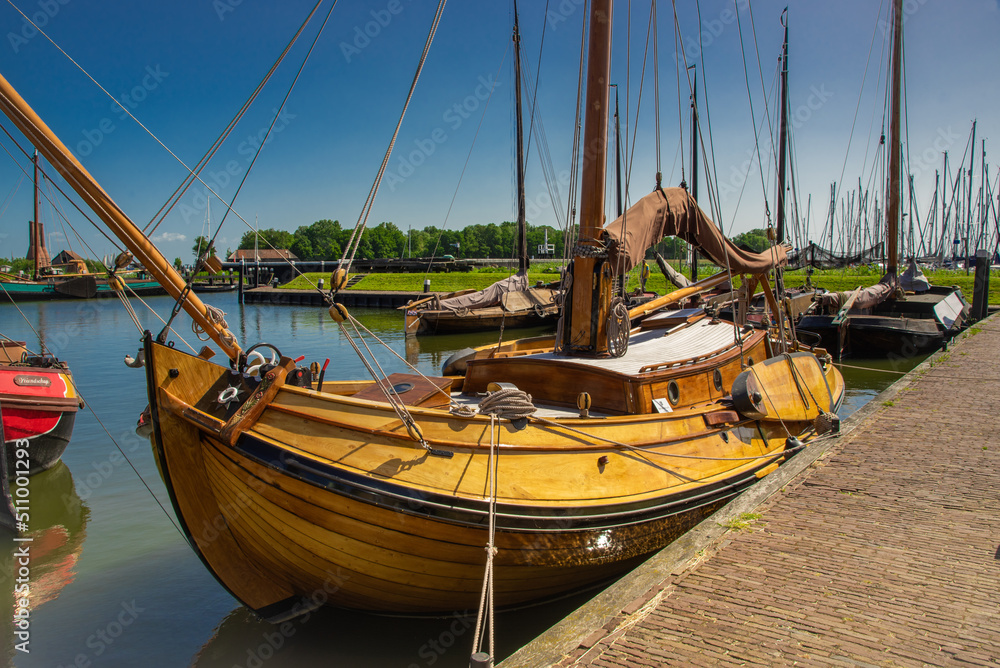 Enkhuizen, Netherlands, June 2022. Old flat-bottomed sailing ships in the harbor of the Zuiderzee Museum in Enkhuizen.
