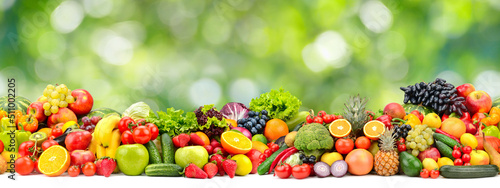 Wide horizontal seamless pattern of vegetables and fruits on green