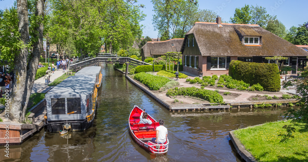 Couple enjoying the histori architecture in a red boat in Giethoorn, Netherlands