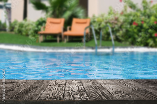 Fototapeta Empty wooden surface near outdoor swimming pool with clear water