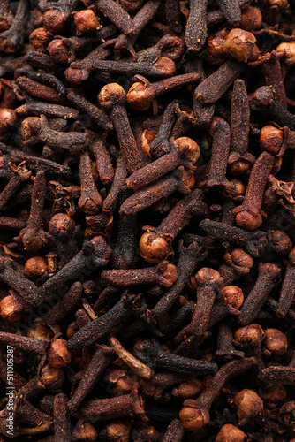 Pile of aromatic cloves as background, top view