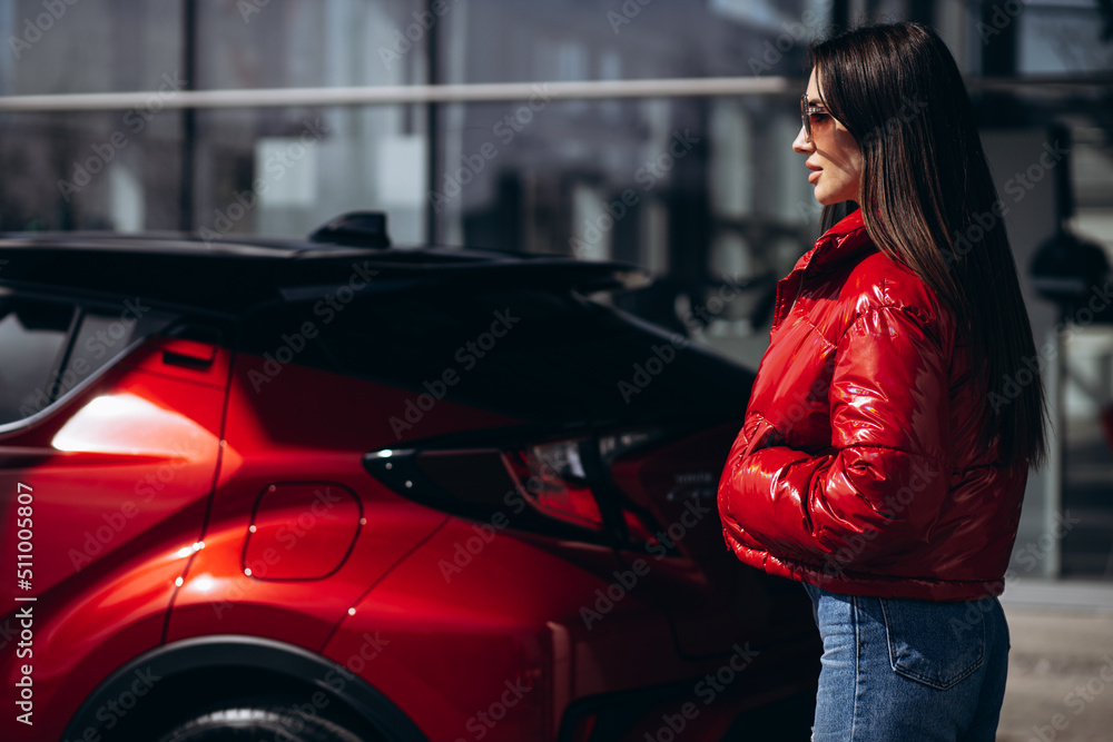 Woman standing by her new red car Woman standing by her new red car