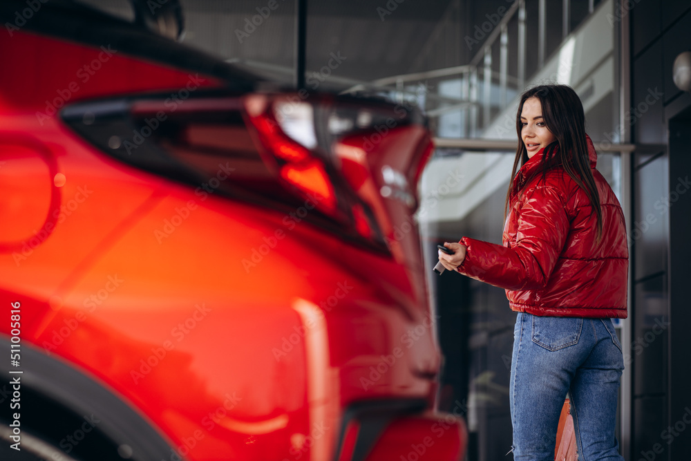 Woman standing by her new red car Woman standing by her new red car