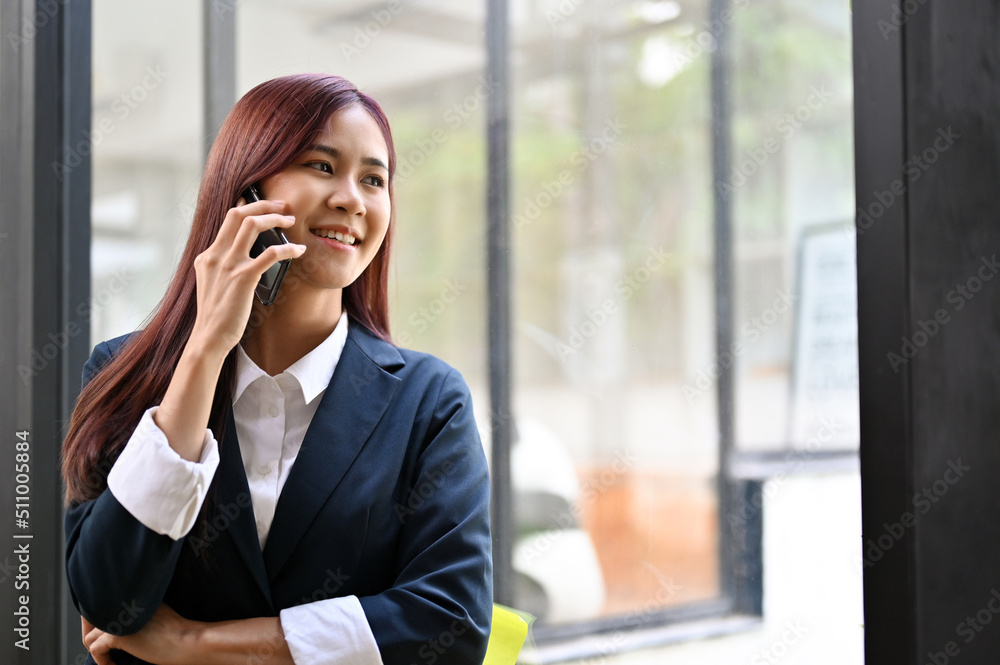 Successful asian businesswoman talking on the phone with her business supplier. Successful asian businesswoman talking on the phone with her business supplier.