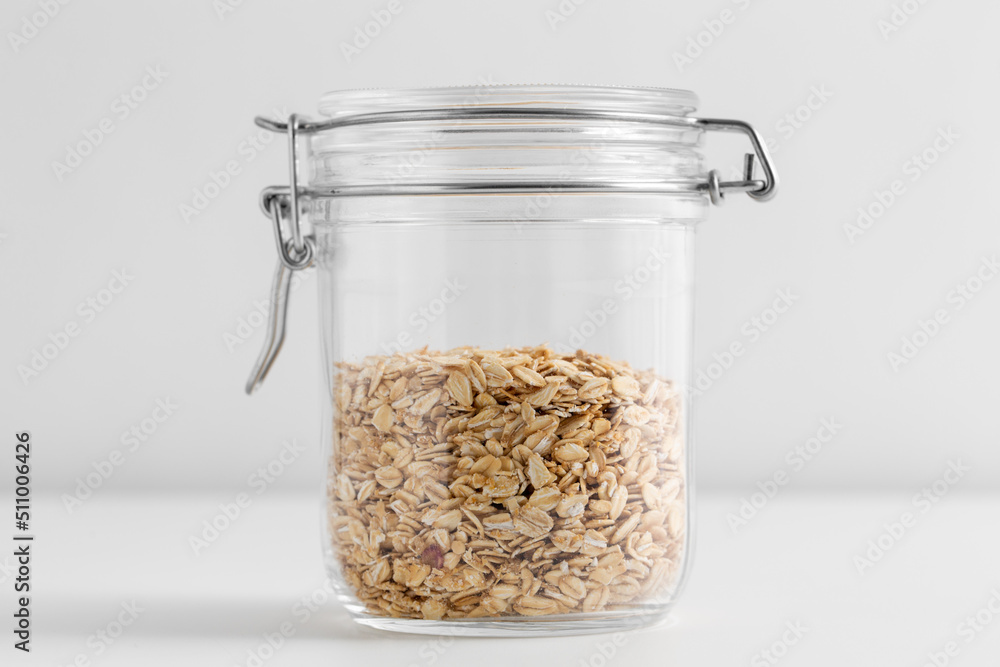 food, healthy eating and diet concept - jar with oat flakes on white background food, healthy eating and diet concept - jar with oat flakes on white background