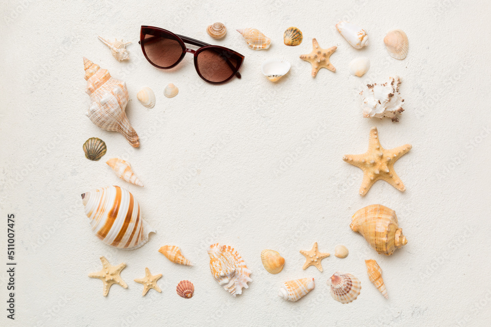 Obraz premium Summer time concept on colored background. Seashells from ocean shore in the shape of frame separated with space for text top view